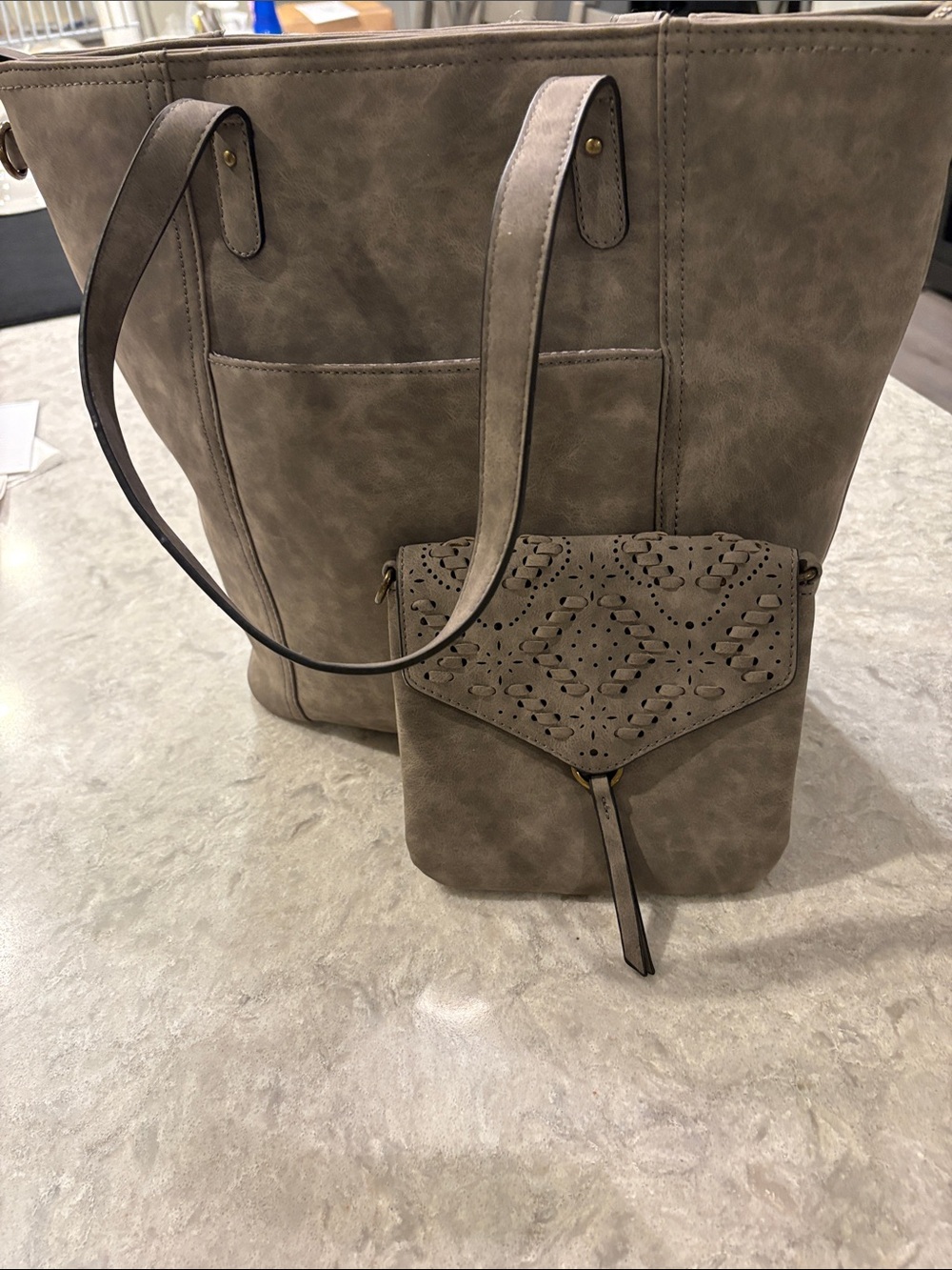 Taupe Faux-Leather wristlet with Perforated design and shaped in razor cut.